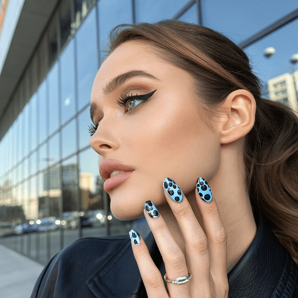 black and blue cow print nails  a woman with black and blue cow print nails